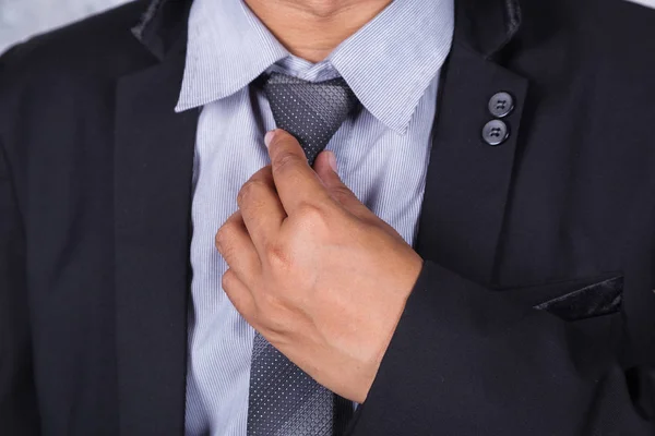 Close up homem de negócios em terno fixando sua gravata — Fotografia de Stock