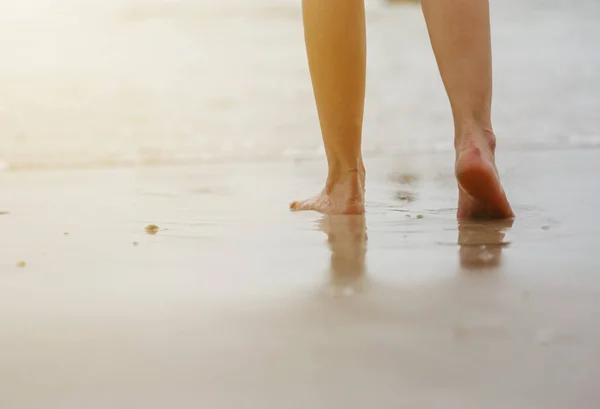 Gros plan des jambes féminines marchant sur la plage — Photo