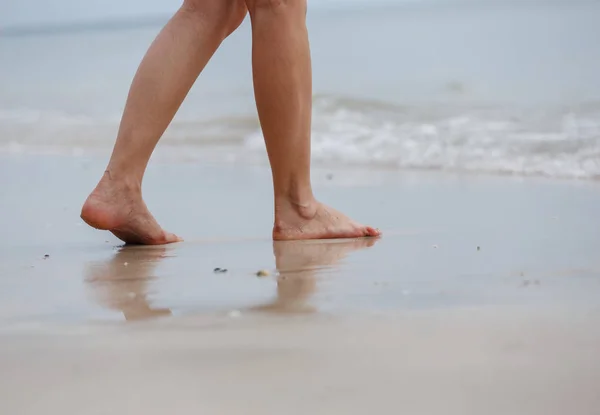 Gros plan des jambes féminines marchant sur la plage — Photo