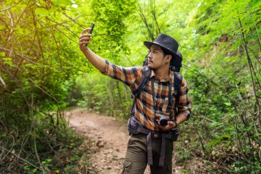 Sırt çantalı bir gezgin kalabalığın sinyalini arıyor.