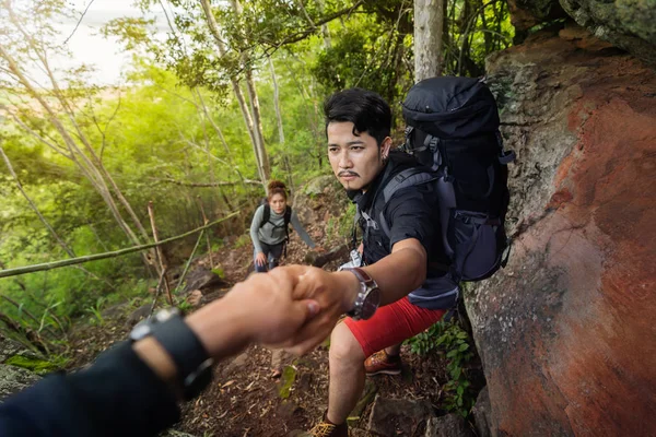 Group of hikers climbing up in forest — Stock Photo, Image