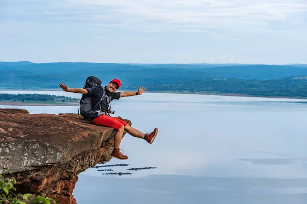 Cheerful Hiker Man Sitting Gesture Raised Arms Edge Cliff Top — Stock Photo, Image