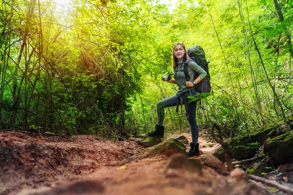 Femme voyageur tenant caméra avec sac à dos debout à l'avant — Photo