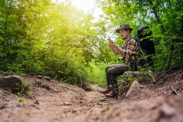 Homme voyageur avec sac à dos en utilisant smartphone dans la forêt — Photo