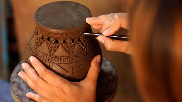 Hands make potter a decorative pattern on earthenware — Stock Photo, Image