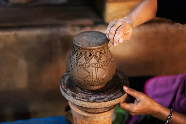 Hands make potter a decorative pattern on earthenware — Stock Photo, Image