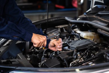Motoru tamir etmek için ingiliz anahtarı kullanan tamirci el, araba servisi.