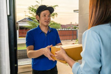 Teslimatçı, evdeki müşteri kadına bir paket teslim ediyor.