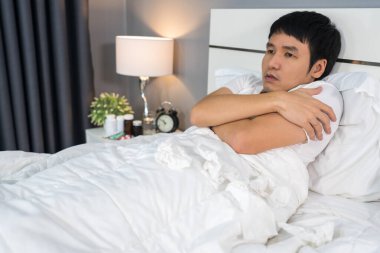 Hasta bir adam yatakta üşüyor.