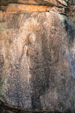 Buda heykeli eski taş duvar.