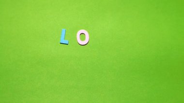 Word'de bir Sevgililer günü yeşil bir arka plan bulanıklık etkisi ile düzenlenmiş farklı renkteki ahşap karakterler