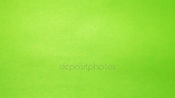 Personajes de madera de diferentes colores dispuestos en una palabra Día de San Valentín sobre un fondo verde con efecto borroso — Vídeo de stock