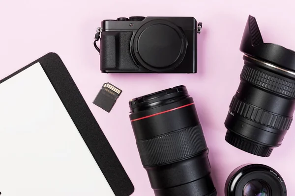 Tarjeta SD de cámara compacta digital vintage con equipo de lentes y libro vacío sobre fondo de color pastel rosa. Plano y espacio de copia para el trabajo de diseño — Foto de Stock