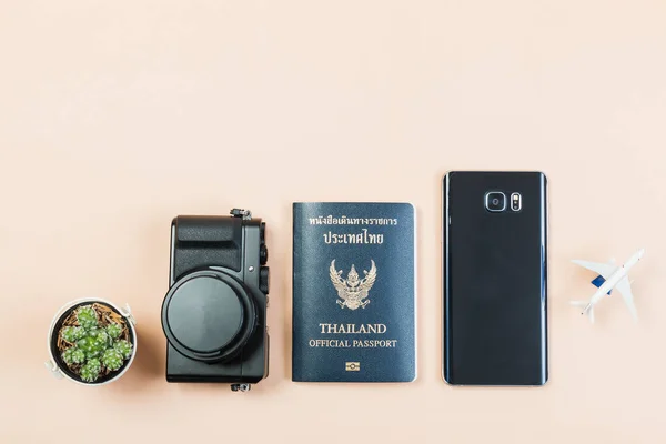 Flache Liege- und Kopierfläche für Designarbeiten einer alten digitalen Kompaktkamera mit thailändischem Reisepass, Smartphone, kleinem Kaktus und kleinem Flugzeug auf gelbem pastellfarbenen Hintergrund. — Stockfoto