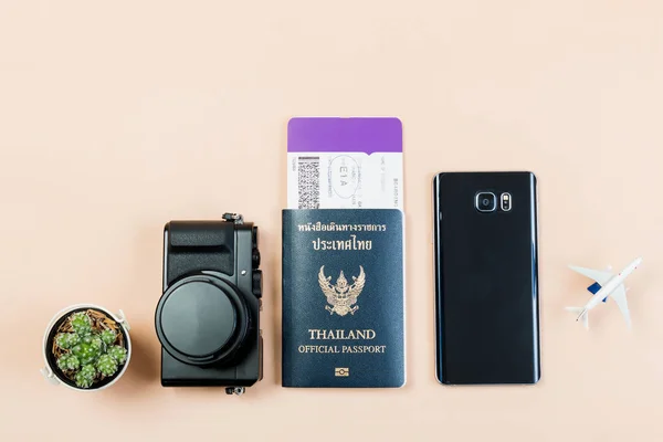 Flat lay e espaço de cópia para o trabalho de design de câmera compacta digital vintage com passaporte oficial da Tailândia, cartão de embarque, telefone inteligente, cacto pequeno e avião no fundo de cor pastel amarelo . — Fotografia de Stock