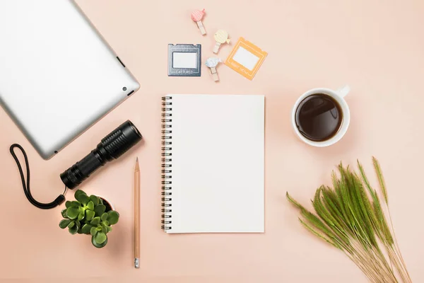 Flach liegend leeres Buch und Bleistift, Tablet für Designarbeiten mit Taschenlampe, Kaffeetasse und kleinem Kaktus auf gelbem Pastell-Hintergrund. — Stockfoto