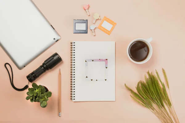 Flat lay libro vacío y lápiz, tableta para el trabajo de diseño con linterna, taza de café y pequeño cactus sobre fondo de color pastel amarillo . — Foto de Stock