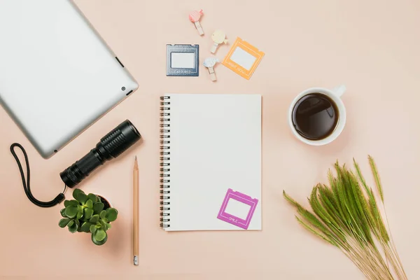 Flach liegend leeres Buch und Bleistift, Tablet für Designarbeiten mit Taschenlampe, Kaffeetasse und kleinem Kaktus auf gelbem Pastell-Hintergrund. — Stockfoto