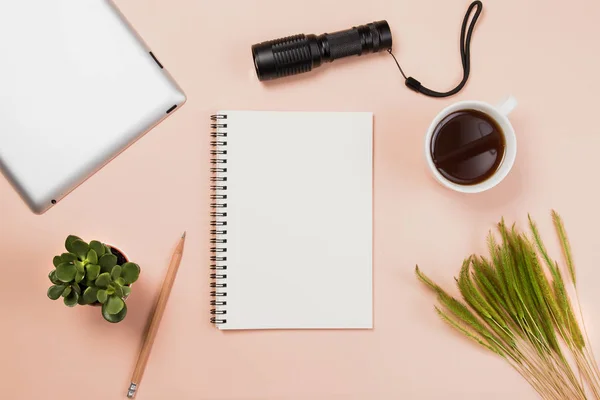 Flach liegend leeres Buch und Bleistift, Tablet für Designarbeiten mit Taschenlampe, Kaffeetasse und kleinem Kaktus auf gelbem Pastell-Hintergrund. — Stockfoto