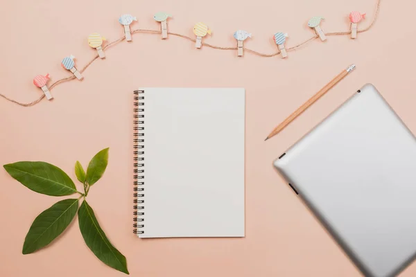 Flat lay libro vacío y lápiz, tableta para el trabajo de diseño con clipper y pequeño cactus sobre fondo de color pastel amarillo . — Foto de Stock