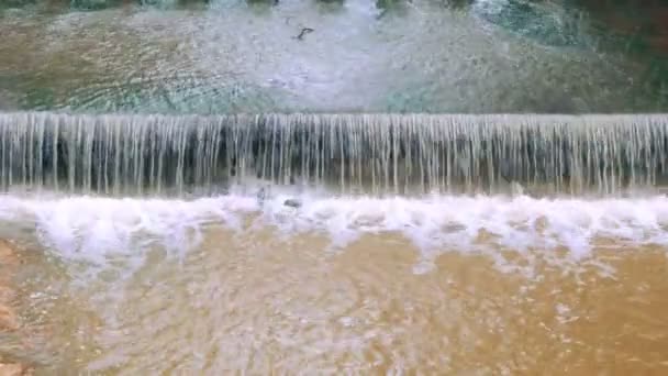 Kontinuerlig vatten rörelse scen för weir eller dam att bromsa flödet av vatten i floden. Det finns färska gröna områden i Thailand. — Stockvideo