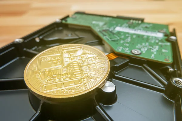 Criptomoneda de oro Bitcoin en la unidad de disco duro con fondo borroso — Foto de Stock