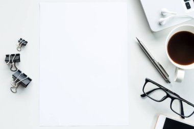 Masanın üstünde boş bir kağıt var. Üst görünüm; düz görünüm.