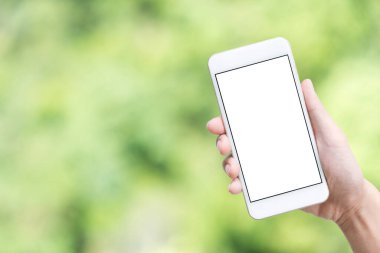 Yeşil soyut arkaplan üzerinde beyaz maket ekran ile el ele tutuşan akıllı telefon.