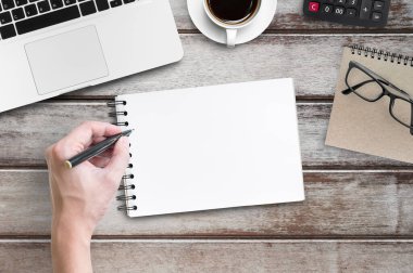 Adam boş defter sayfasına bir şeyler yazacak. Üst manzara, düz uzanma.