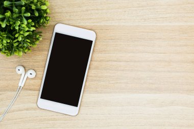 Beyaz ekranlı akıllı telefon ahşap masada. Kopyalama alanı olan üst görünüm, düz yatay.