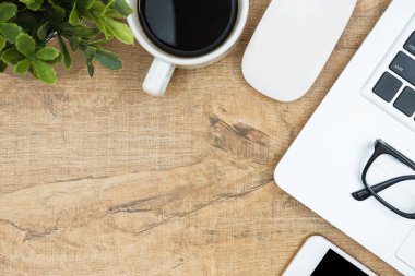 Laptoplu ahşap masa, kahve ve malzemeler. Kopyalama alanı olan üst görünüm, düz yatay.