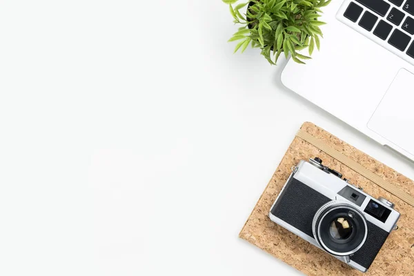 White photographer desk table with film camera, laptop and supplies. Top view with copy space, flat lay.