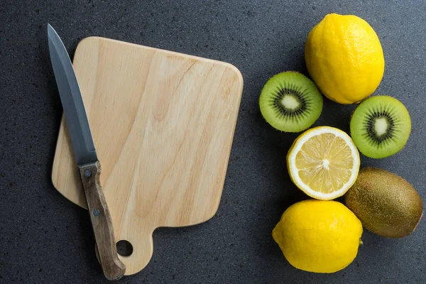 The lemons are on top of wood cutting board with knife. Top view with copy space, flat lay.