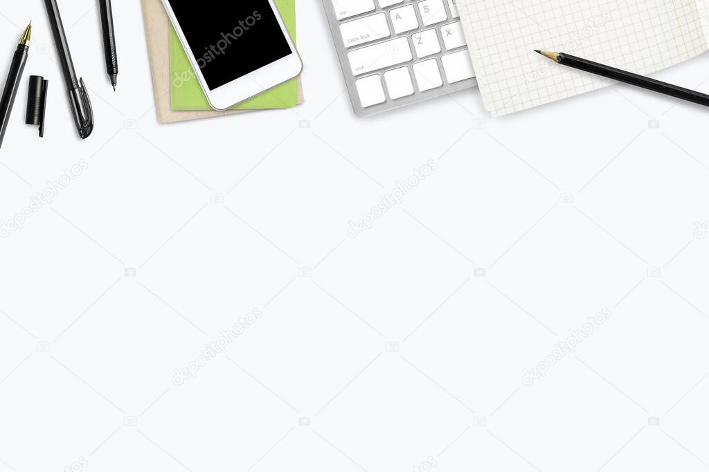 White office desk table with white smartphone with blank screen, notebook, laptop computer and supplies.