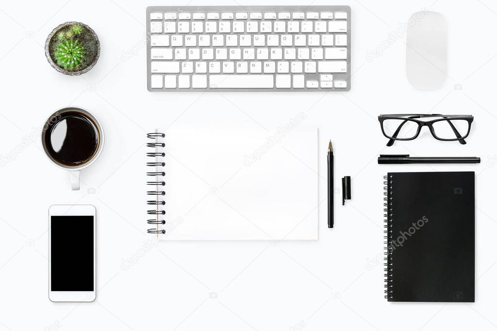 White desk table with blank notebook in the middle with supplies. Top view, flat lay.