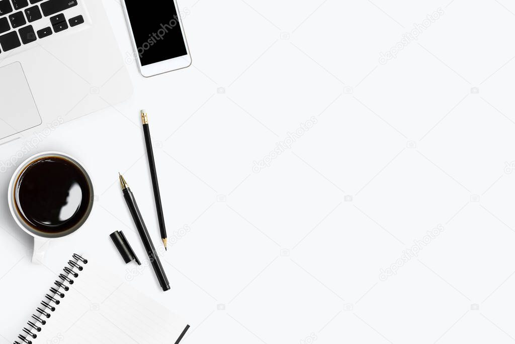 White office desk table with white smartphone with blank screen, notebook, laptop computer and supplies.