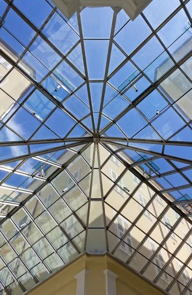 Bouw- en blauwe hemel buiten een glazen dak — Stockfoto