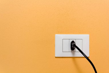 Siyah fiş prize turuncu bir duvar