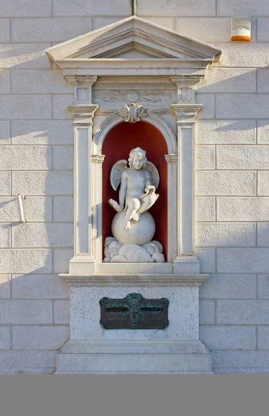 Nische mit einer Kinderengel-Skulptur auf einem neoklassizistischen Gebäude in — Stockfoto