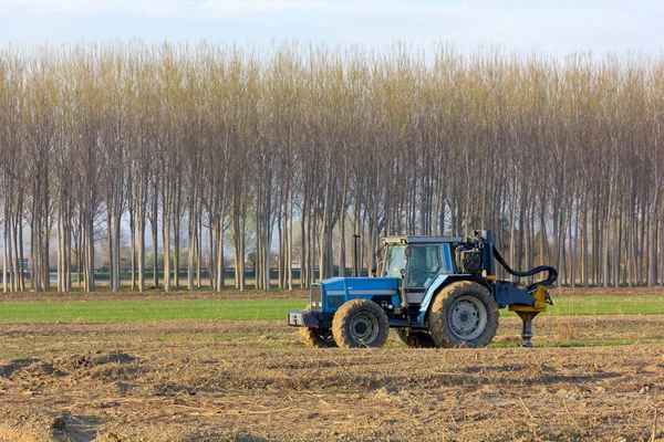 Blauer Traktor mitten auf einem Feld — Stockfoto