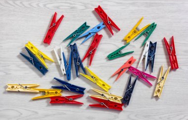 Beyaz ahşap doku üzerinde renkli clothespins dönüştürün