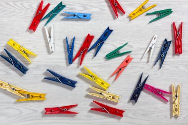 Beyaz ahşap doku üzerinde renkli clothespins dönüştürün
