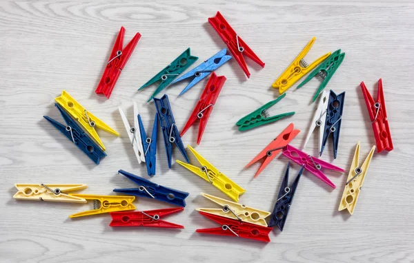 Beyaz ahşap doku üzerinde renkli clothespins dönüştürün
