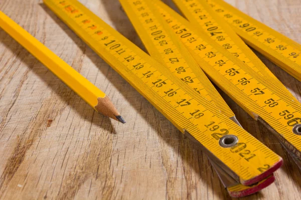 Kij pomiarowych i ołówek na drewnianym stole — Zdjęcie stockowe