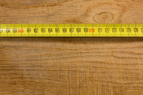 Taśma pomiarowa na drewnianym stole — Zdjęcie stockowe