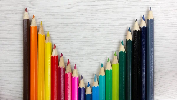 सफेद लकड़ी पृष्ठभूमि पर रंगीन पेंसिल — स्टॉक फ़ोटो, इमेज
