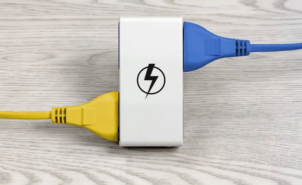 Dois cabos coloridos conectados a um soquete múltiplo — Fotografia de Stock