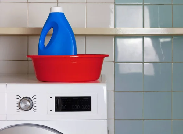 Botella de detergente de lavandería en un cuenco de lavado en una sala de lavandería —  Fotos de Stock