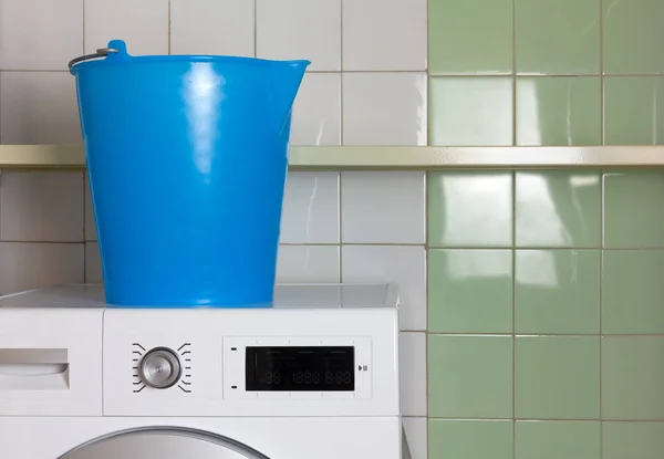 Seau sur une machine à laver dans la blanchisserie — Photo
