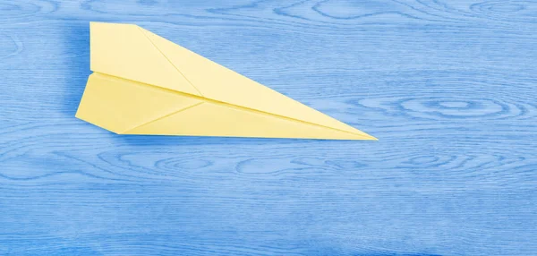 Żółty Papierowy Samolot Nad Drewnianym Niebieskim Tłem Przypominającym Błękitne Niebo — Zdjęcie stockowe